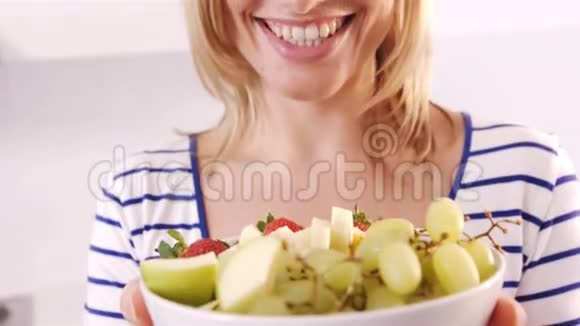 金发女人微笑着拿着水果碗视频的预览图