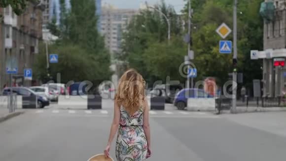 美丽的金发女郎戴着帽子在城市里走来走去视频的预览图