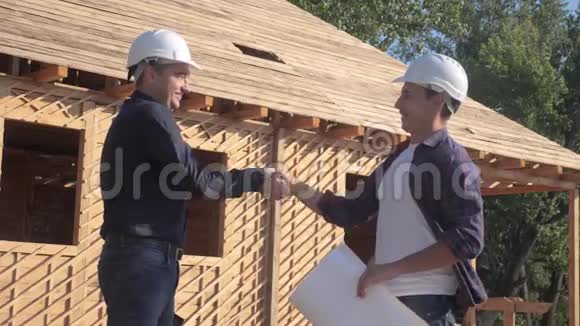 团队合作概念建设构建建筑师慢动作视频两个戴头盔的人握手契约视频的预览图