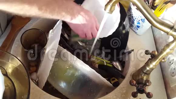 特写男士用手洗盘子用水喷射从泡沫和洗涤剂中冲洗盘子视频的预览图