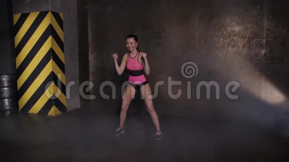 运动美女在健身房做运动健身房训练常规黑暗阁楼大厅视频的预览图