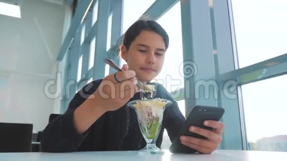 机场等待飞机航班十几岁的女孩吃沙拉看上去像智能手机在咖啡馆里上网机场视频的预览图
