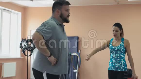 从运动女孩为大腹便便的胖男孩进行个人训练胖子训练女教练视频的预览图