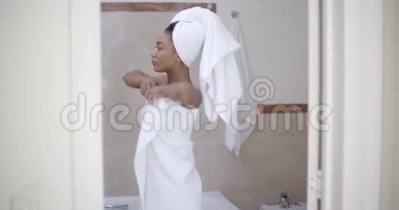 头戴毛巾的女人在浴室里视频的预览图