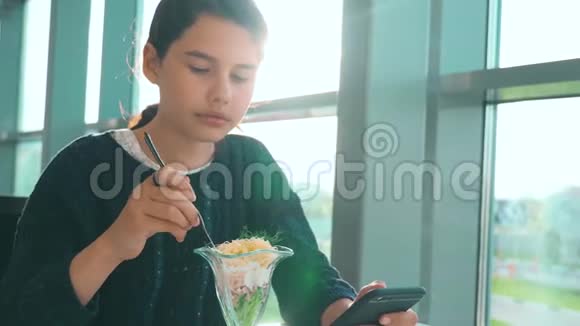 机场等待乘坐生活方式飞机的航班十几岁的女孩吃沙拉看上去像智能手机在咖啡馆里上网机场视频的预览图