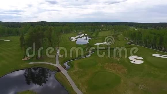 鸟瞰高尔夫球场池塘和高尔夫球场的绿色草坪美丽高尔夫球场的沙堡视频的预览图