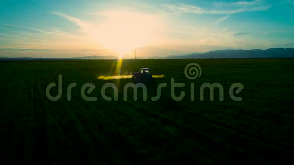 农用拖拉机耕田喷洒的空中日出景观视频的预览图