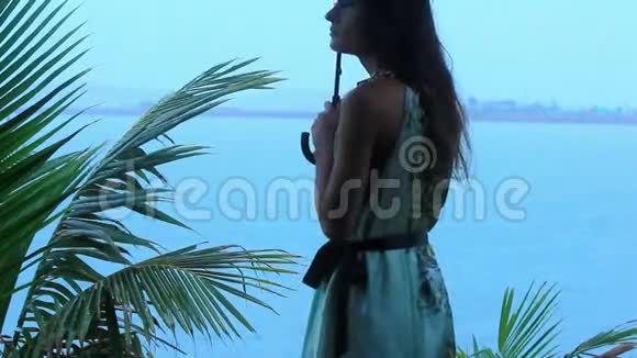 热带海滩上的年轻女子带着雨伞视频的预览图