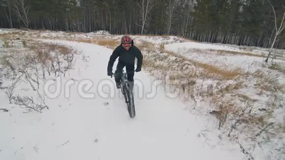 专业的极限运动员骑自行车在户外骑胖自行车骑自行车在冬天的雪林里男人是审判视频的预览图