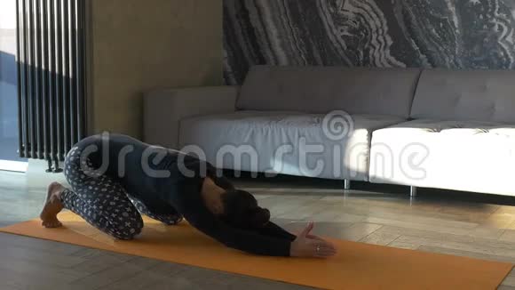 女孩在客厅练习瑜伽视频的预览图