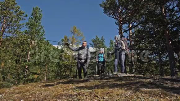 家庭旅行人的环境由山河溪组成父母和孩子用跋涉杆走路人与人视频的预览图