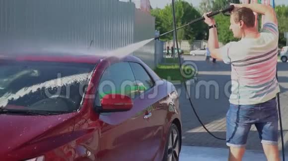 年轻的白种人正在洗车自助服务洗车视频的预览图