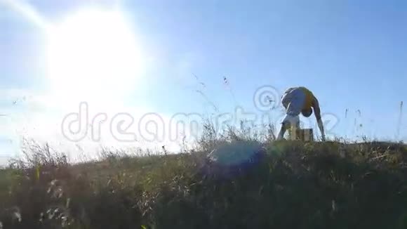 在户外练习瑜伽动作和姿势的人年轻男子站在瑜伽姿势的自然做体力活的运动员视频的预览图