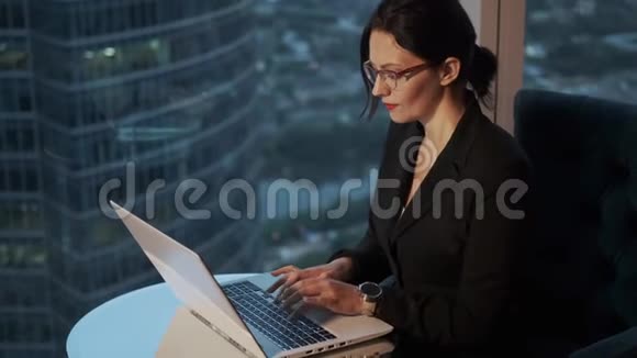 现代商务女性晚上在笔记本电脑上工作办公室里戴眼镜的女商人的肖像视频的预览图