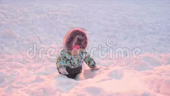 一个小孩子在冬天公园玩晴朗的冬日新鲜空气中的乐趣和游戏视频的预览图