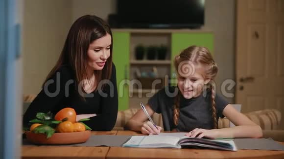 母亲和女儿做学校作业妈妈帮忙处理视频的预览图