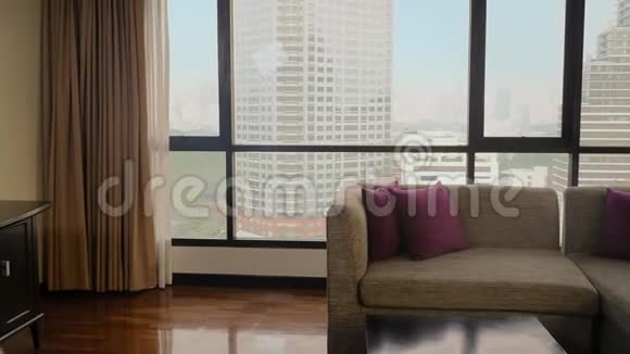 一个女人带着一个手提箱在摩天大楼的背景下在一个全景窗口视频的预览图