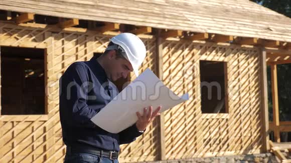 概念建筑构建建筑师慢动作视频戴着头盔的建筑工人站在一座建筑前视频的预览图