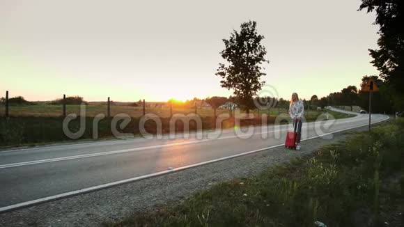 年轻女子在乡间路上搭便车视频的预览图