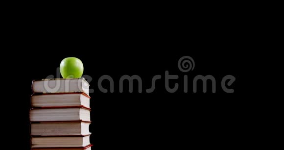 书堆上的绿苹果视频的预览图