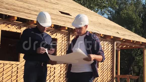 团队合作概念建设构建建筑师慢动作视频两个戴头盔的男性生活方式建设者研究视频的预览图