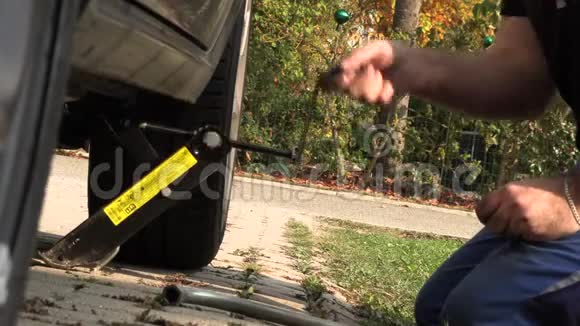 一个穿着工作裤的男人取代了汽车车轮慢动作视频的预览图