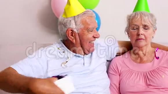 年长夫妇在沙发上庆祝生日视频的预览图