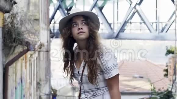 戴帽子的年轻女子走在波尔图的老街上视频的预览图