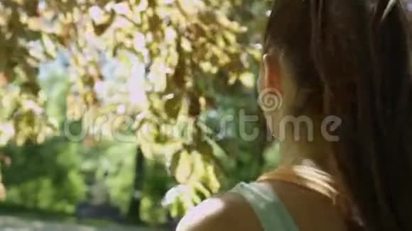 年轻漂亮的女人在阳光明媚的公园里散步享受大自然视频的预览图