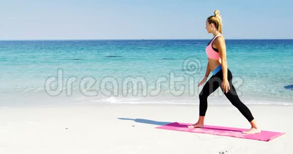 适合在海滩做伸展运动的女人视频的预览图