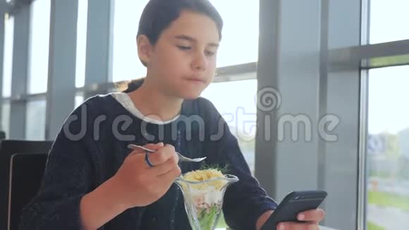 机场等待飞机航班少女生活方式吃沙拉看起来像智能手机在咖啡馆里上网机场视频的预览图