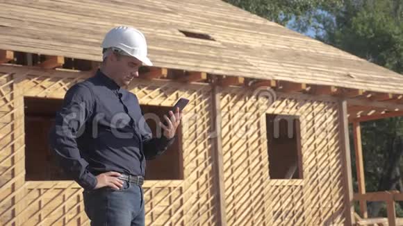概念建筑构建建筑师慢动作视频戴着头盔的男建筑工人站在建筑工人手中视频的预览图