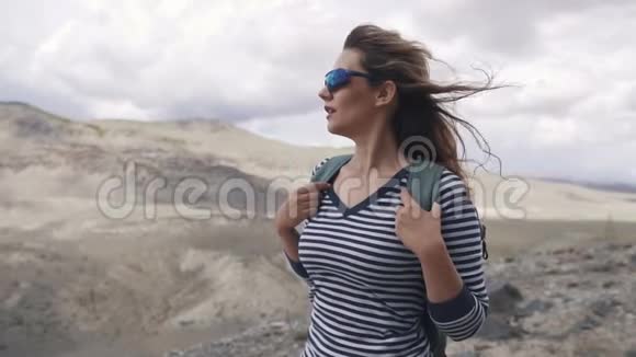 旅行者的肖像女徒步旅行者带背包背景是群山视频的预览图
