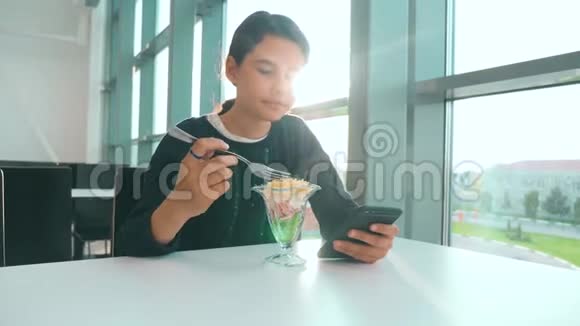机场等待飞机航班十几岁的女孩吃沙拉看上去像智能手机在咖啡馆里上网生活方式机场视频的预览图