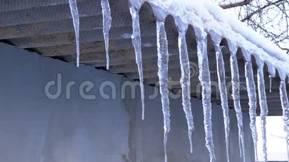 屋顶上融化的冬日冰柱正在滴水视频的预览图