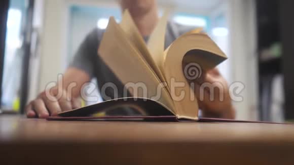 人在看一本书慢动作视频教育学习图书馆的概念男人打开生活方式这本书男人转身视频的预览图