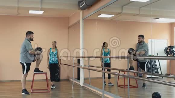 胖子和女教练一起训练在健身中心做运动厚肥胖的家伙和个人视频的预览图