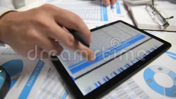 商人与平板电脑合作计算阅读和撰写报告办公室员工桌子特写商业金融视频的预览图