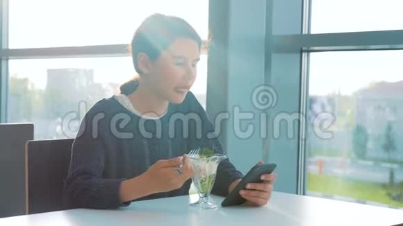 机场等待飞机航班十几岁的女孩吃沙拉看上去像智能手机在咖啡馆里上网机场候机楼视频的预览图