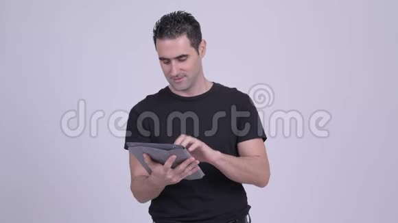 快乐的帅哥在用白色平板电脑思考视频的预览图