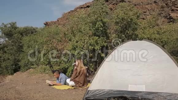 几个徒步旅行者在温暖的阳光下在帐篷附近休息视频的预览图
