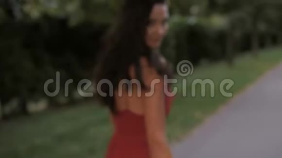穿红色连衣裙的时尚女性肖像散步女孩视频的预览图
