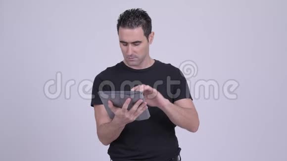 帅哥在白色背景下使用数码平板电脑时思考视频的预览图
