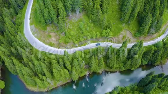 从飞机上可以看到汽车行驶在前方和湖边美丽的山路在山路上开车道路视频的预览图
