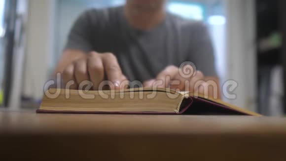 人在读一本书教育学习概念库生活方式男人打开了这本书人翻书页视频的预览图