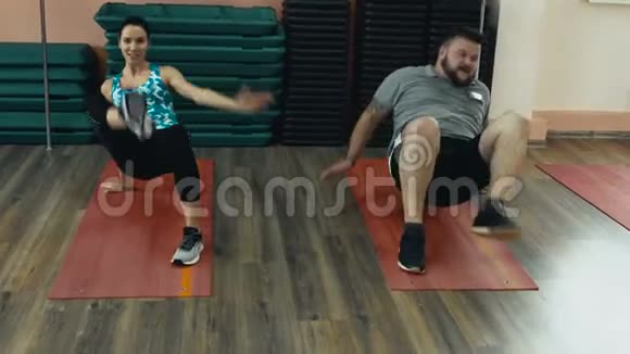 肥胖男子和个人苗条教练一起在健身房做体育锻炼男女教师超重视频的预览图