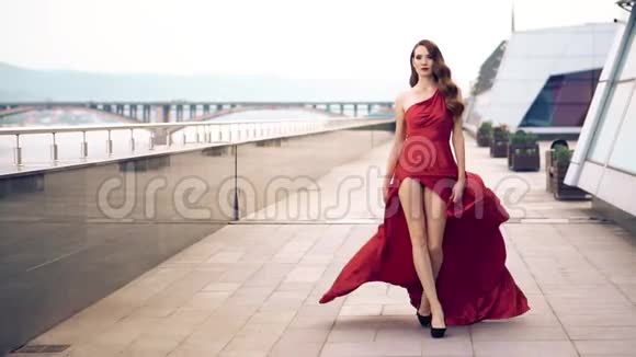 美丽的女人穿着红色飘舞的连衣裙视频的预览图