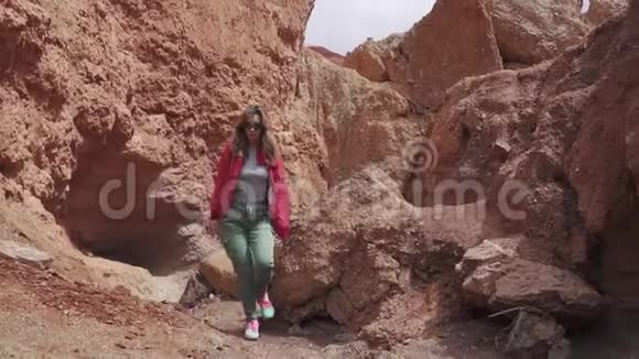 戴太阳镜的女游客在一个不寻常的地形上红色的山脉和红色的地球就像火星一样视频的预览图