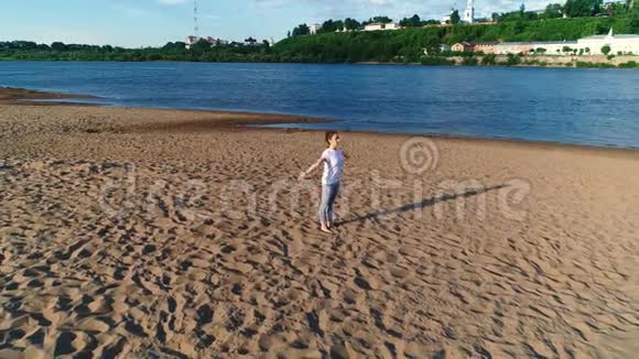 女人在城市河边的海滩上做瑜伽美丽的景色视频的预览图