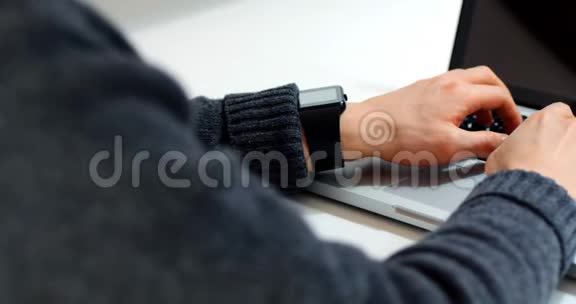 男性高管中段在办公桌上使用笔记本电脑视频的预览图